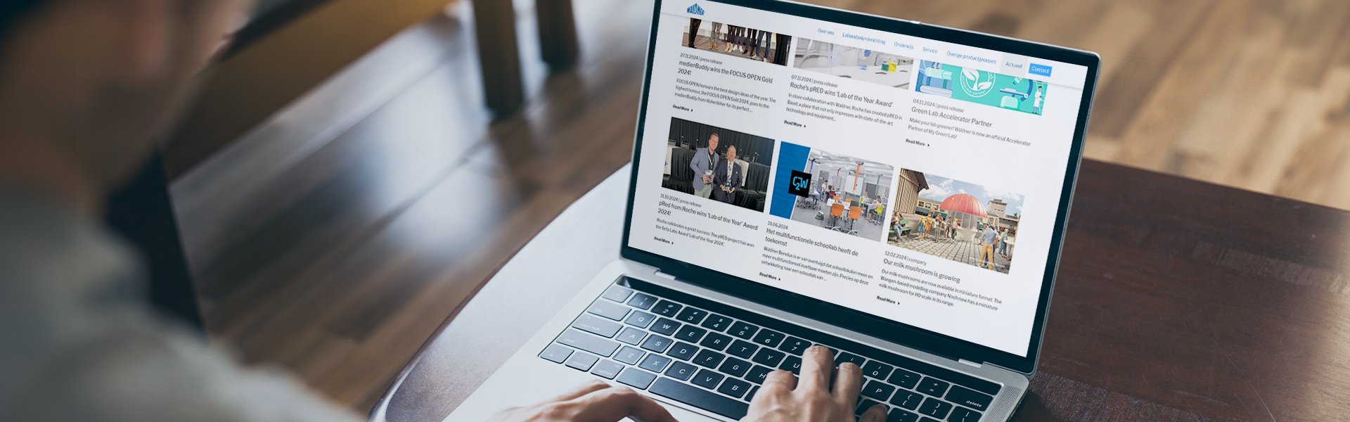 Person scrolt op zijn laptop door het nieuws van Waldner.